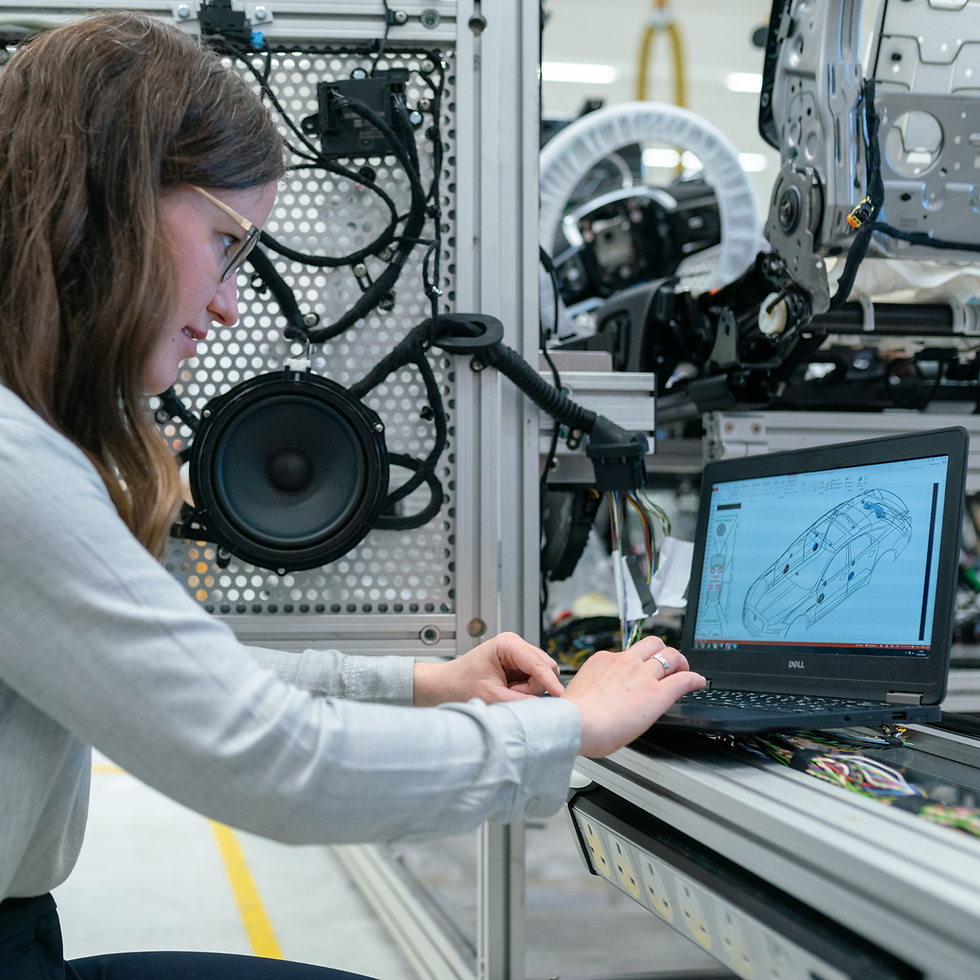 Ingenieurin in der Automobilindustrie analysiert Fahrzeugkomponenten mit CAD-Software am Laptop in der Fertigung