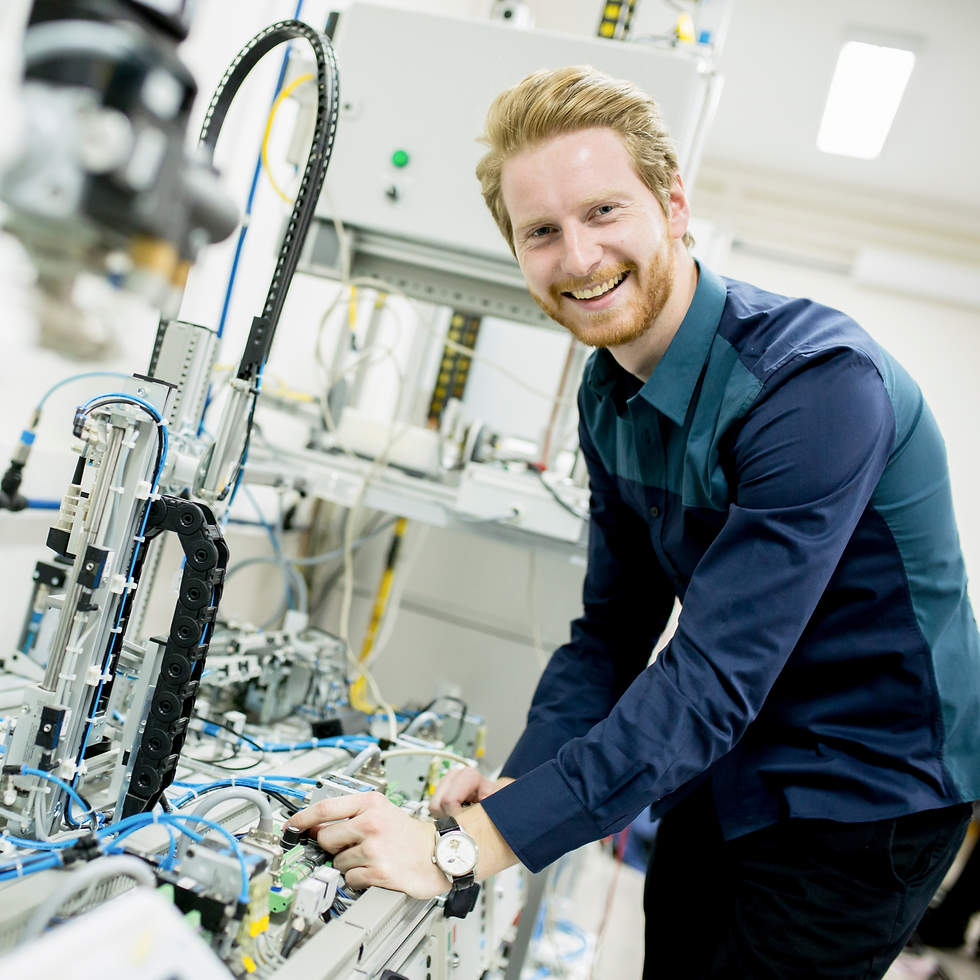 Ingenieur im Maschinen- und Anlagenbau arbeitet an einer automatisierten Produktionsanlage und prüft die Steuerungstechnik