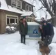 Snowy scene with four students and dog in front of Cascade Crest Transitions' ATC Building. 