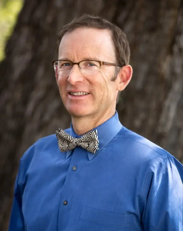 man standing in front of tree smiling