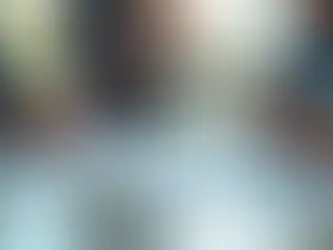 Mesa de reunião com documentos de contrato, laptop e mãos de pessoas em discussão profissional