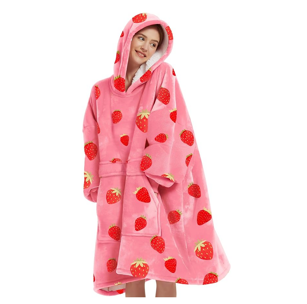 A person wearing a pink oversized plush hoodie with strawberry patterns, smiling, isolated on a white background. Cozy and cheerful mood.