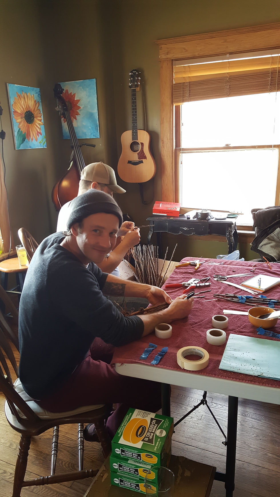 Man sitting at table prepares to graft trees.