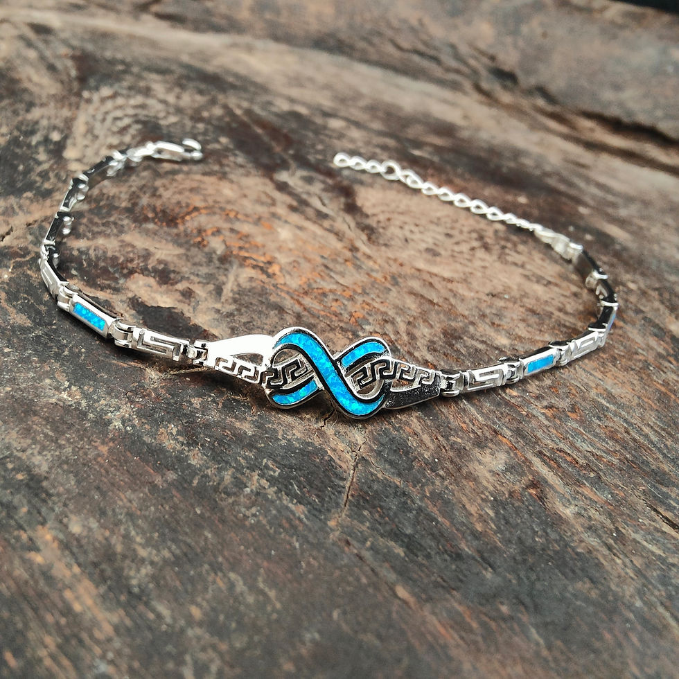 Silver bracelet with turquoise infinity symbol on wooden background. Thetistreasures.