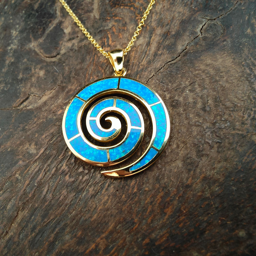 Thumbnail: Spiral pendant necklace with bright blue stone, displayed on dark wooden surface.