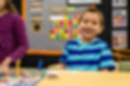 A happy student at Trinity Lutheran Church, School, & Childcare playing an educational board game