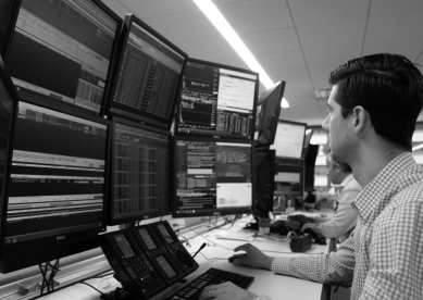 Trader monitoring multiple financial data screens