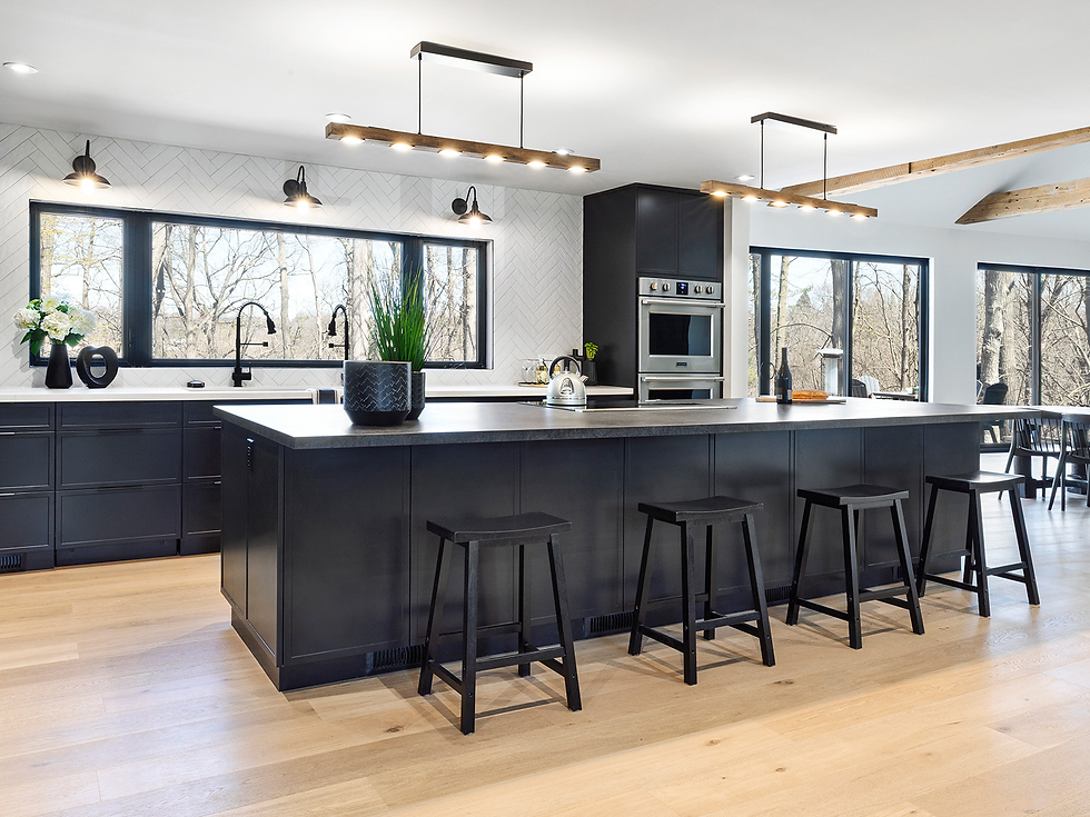 Wide landscape photo of a modern black kitchen with a long island, bar stools, wood floor, and large windows, landscape aspect ratio.