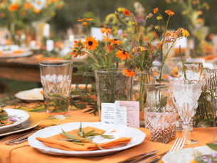 Fall decorated table in soft yellow tones with candles and yellow flowers.
