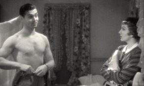 Clark Gable and Claudette Colbert share a motel room in a screencap from 'It Happened One Night.' The most shocking part? Clark was sans undershirt.