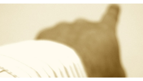 Unschärfe Bild eines Arms in weißem Hemd, der nach oben zeigt. Sepia-Ton schafft eine nostalgische Stimmung.