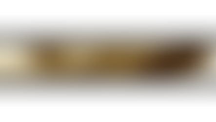 Nahaufnahme einer alten, sepiafarbenen Ampel mit leuchtendem Licht. Die Struktur wirkt rostig und befindet sich vor einer weißen Wand.