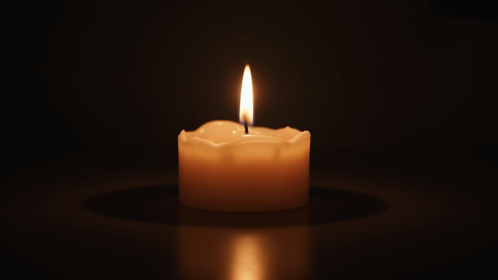 Close-up view of a softly glowing candle in a dark room