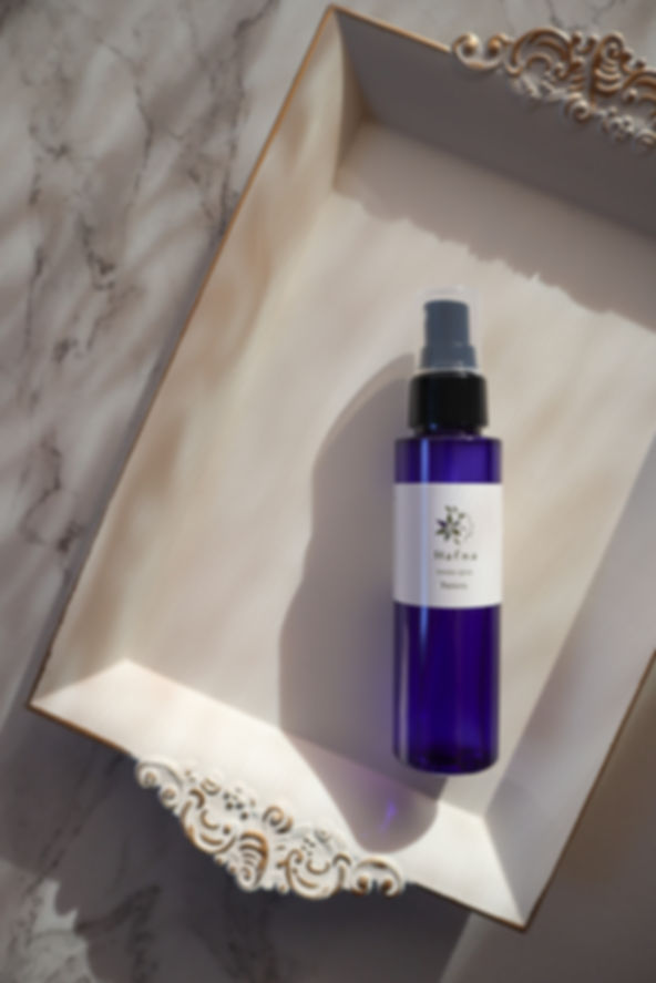 青いスプレーボトルがアンティーク調のトレイに置かれている画像。