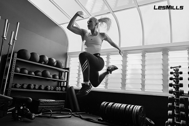 Γυναίκα κάνει άλμα, LesMills, γυμναστήριο, ασκήσεις, αθλητικό ένδυμα, προπόνηση, GRIT.