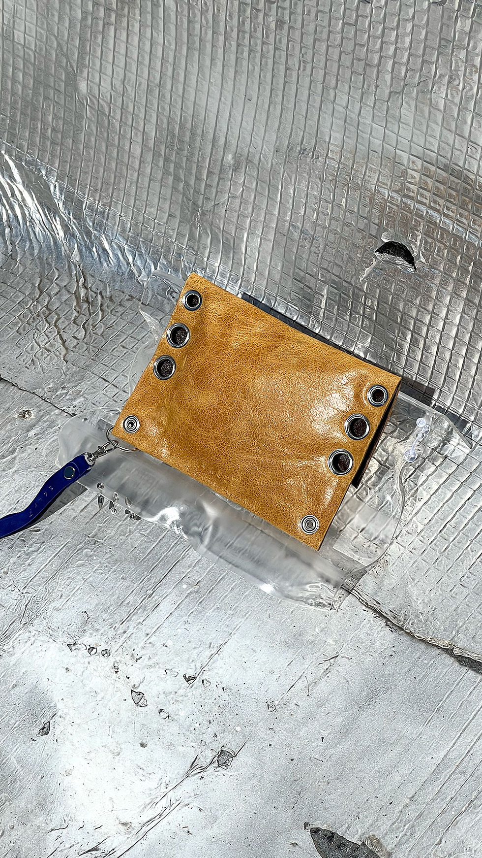 Pochette porte feuille en cuir brun clair avec œillets et ornements métalliques