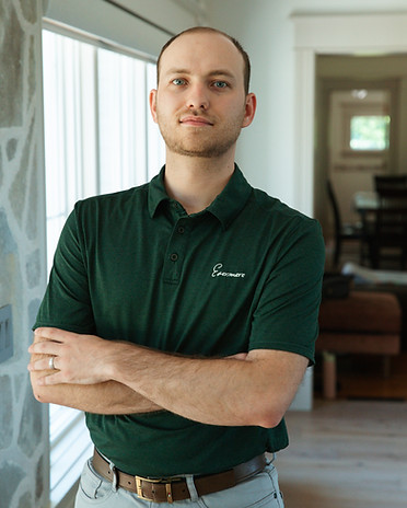 man standing in front of window in green shirt