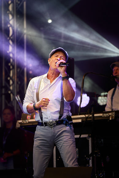 Konzert in vollem Gange, close up des Sängers von Klüngelköpp beim Singen, farbenfroh, Karnevalsband Klüngelköpp beim Abgang von der Bühne, Nacht, Rauch, farbige Scheinwerfer