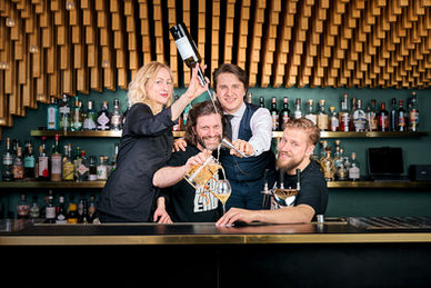 Professionelle Food- und Cocktail-Fotografie eines Barkeeper-Moments: Ein Signature Drink wird präzise durch ein Sieb in ein elegantes Cocktailglas abgeseiht – inszeniert mit atmosphärischem Bar-Ambiente und warmem Hintergrundlicht. Die Kombination aus Bewegung, Detailtiefe und authentischer Stimmung erzeugt eine hochwertige, markenstarke Bildwirkung mit starkem Storytelling-Charakter. Ideal für Bars, Restaurants, Spirituosenmarken, Hotelgastronomie, Eventmarketing und Social Media Kampagnen. Moderne Gastronomie- und Getränkefotografie für Websites, Werbung und Branding – emotional, hochwertig und verkaufsorientiert zur gezielten Steigerung von Sichtbarkeit, Reichweite und Markenimage.