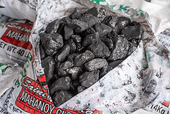 A bag of Anthracite Coal that has been open to reveal the contents.