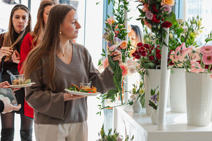 Woman holding a flower stem at a floral workshop