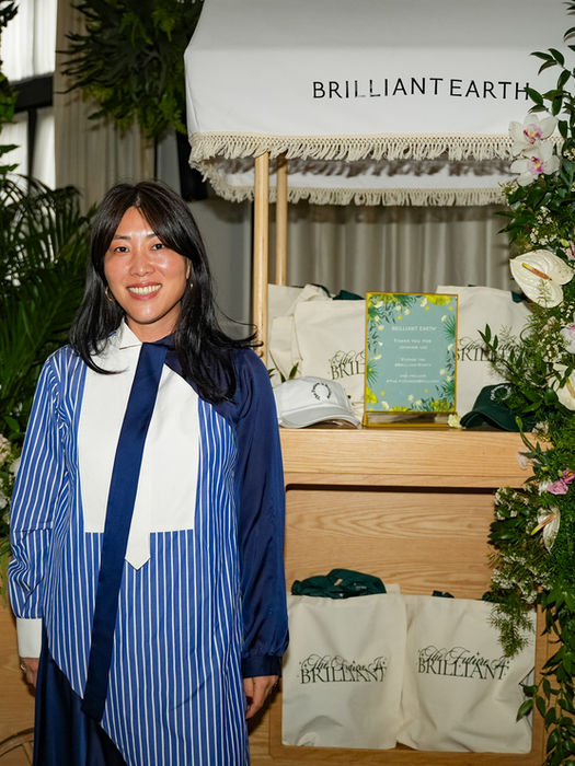 Woman at a Brilliant Earth event booth with floral decor