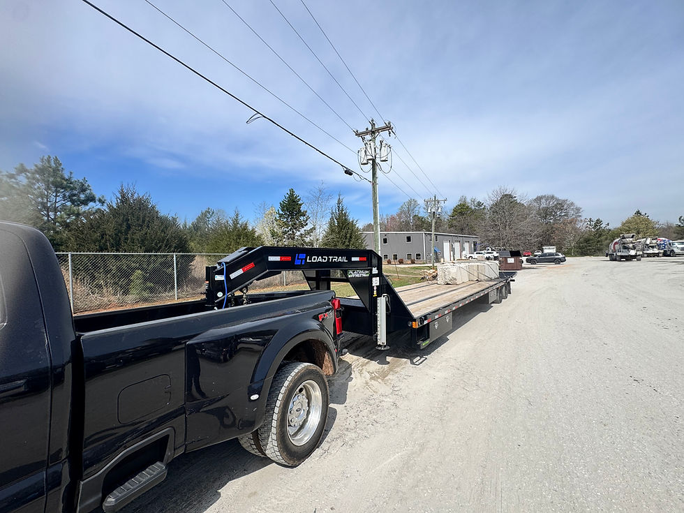 Hauling construction materials on 40' gooseneck flatbed with hydraulic Dovetail