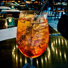 Tall wine glass filled with ice and a golden orange liquid