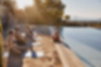 A group of people meditating close to the pool during a yoga retreat in Greece
