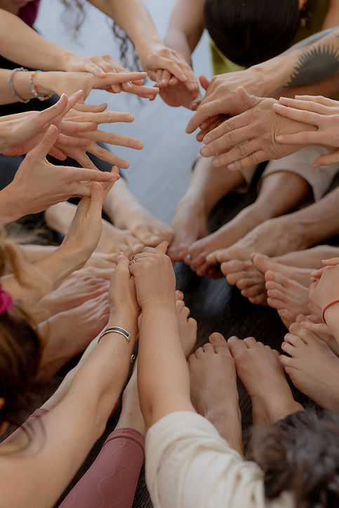 People connecting with their hands in a circle during an Evexia yoga retreat.