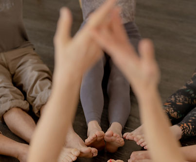 Group of retreat participants holding hands, symbolizing connection and community.