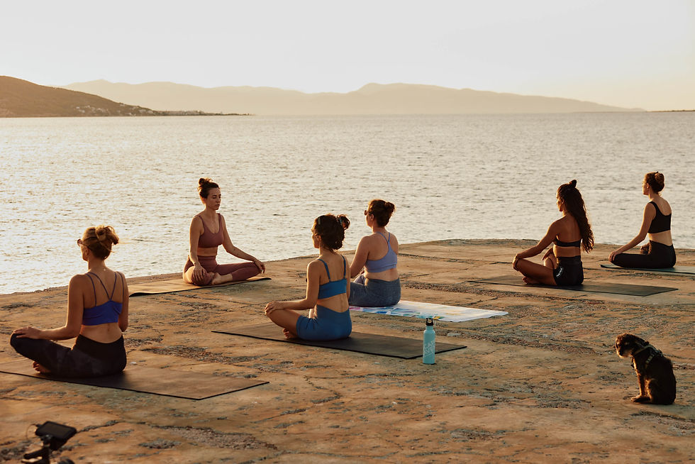 People meditating at the sea in Greece during a wellness retreat.