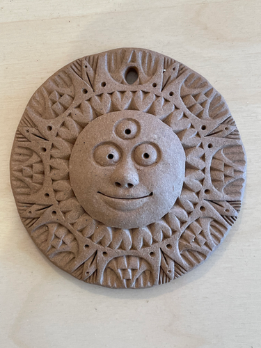 Terracotta sun face by Dana Swisher