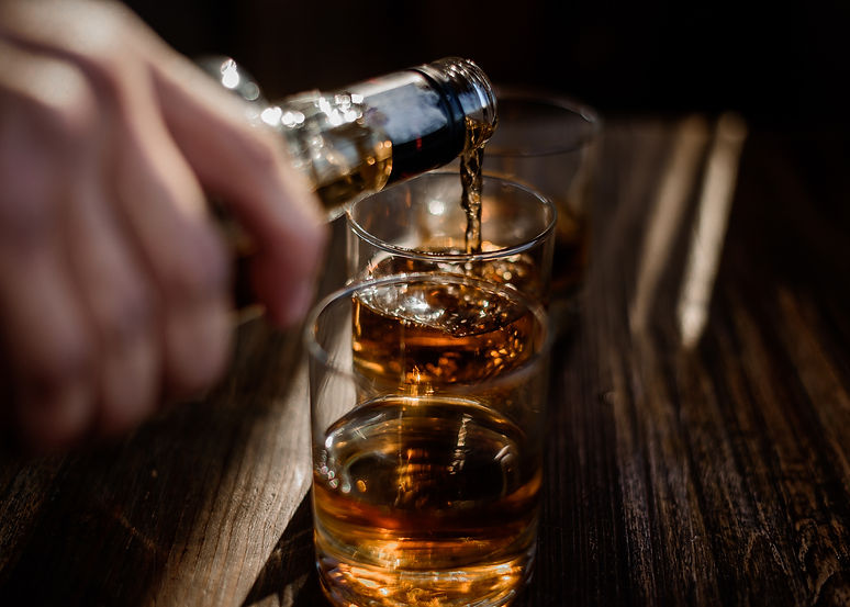pouring-strong-alcohol-drink-into-glasses-which-are-wooden-table.jpg