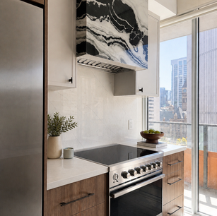 Condo kitchen. Stone custom hood. 