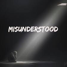 A person sits curled up under a spotlight in a dark room. Bold text reads "MISUNDERSTOOD." The scene conveys loneliness and isolation.