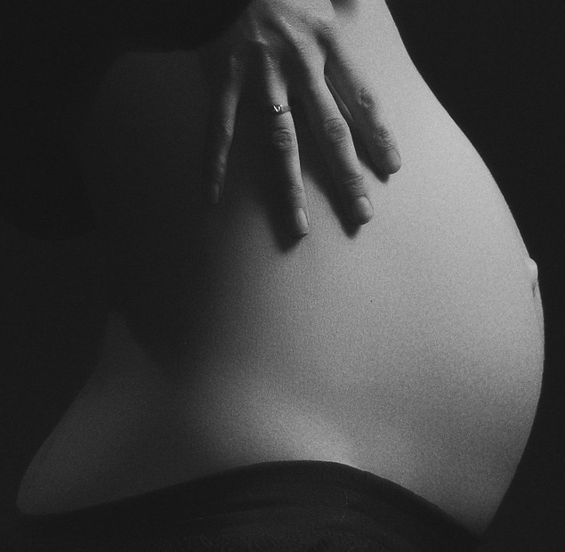 grayscale-photo-of-pregnant-woman-holdin