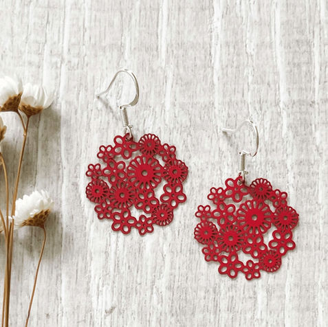 Red circle earrings on hooks with a filigree style pattern
