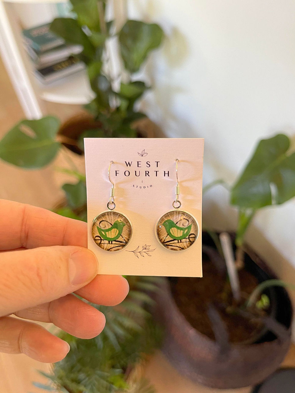 Thumbnail: Green bird earring close up