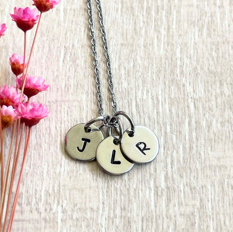 Three circle stainless steel charms each with a letter on a chain