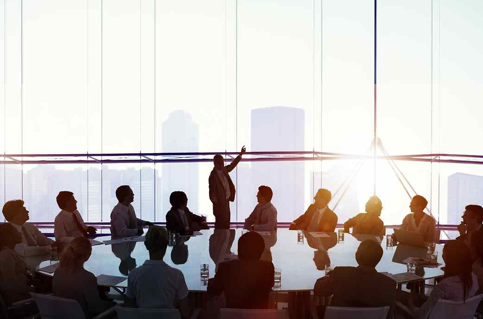 Meeting with leader pointing out the window towards the skyline.