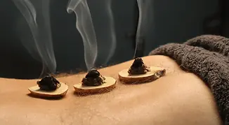 Moxibustion-pratiquee-sur-le-dos-dune-personne.webp