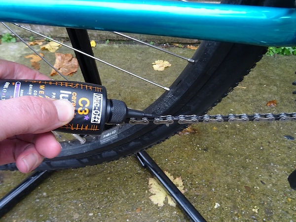 muc-off cs bicycle chai lube being applied to a bicycle chain