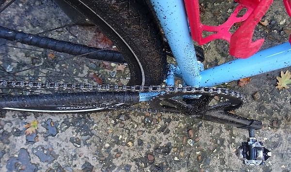 bicycle chain, chain rings, chain stays. covered in dirt
