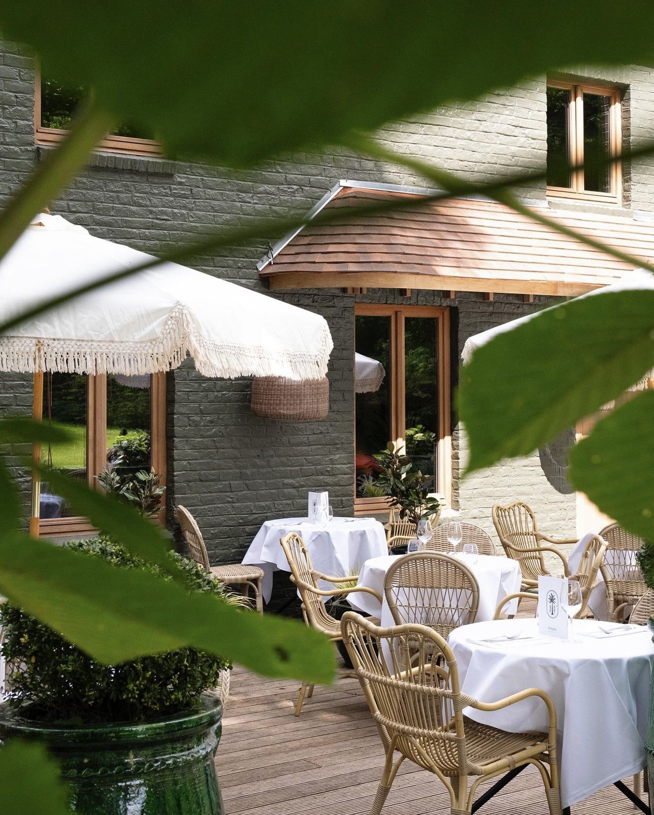 La terrasse, parasols à franges et fauteuils en rotin