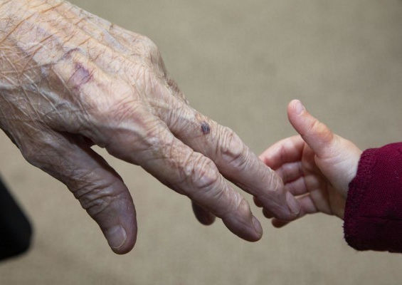 Picture of elderly resident and child holding hands