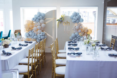 Fancy tables and decor and balloons and backdrop for a boy baby shower