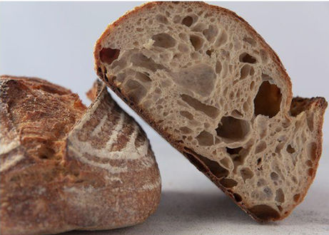 Crusty bread loaf cut open showing texture, fresh baked loaf, rustic sourdough.