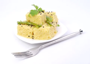 Dhokla with coriander, mustard and fried chillies.