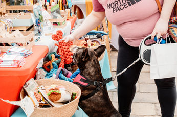 Woman and dog at market, North Face shirt, dog reaching, Dreamers Markets.